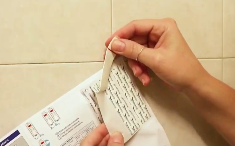 Coge una tira adhesiva de las instrucciones del producto