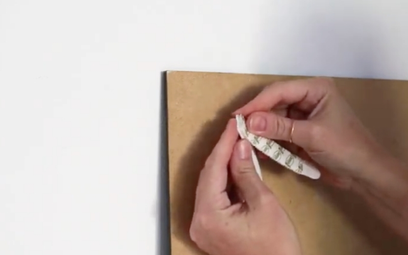 Retira el papel protector de la tira adhesiva