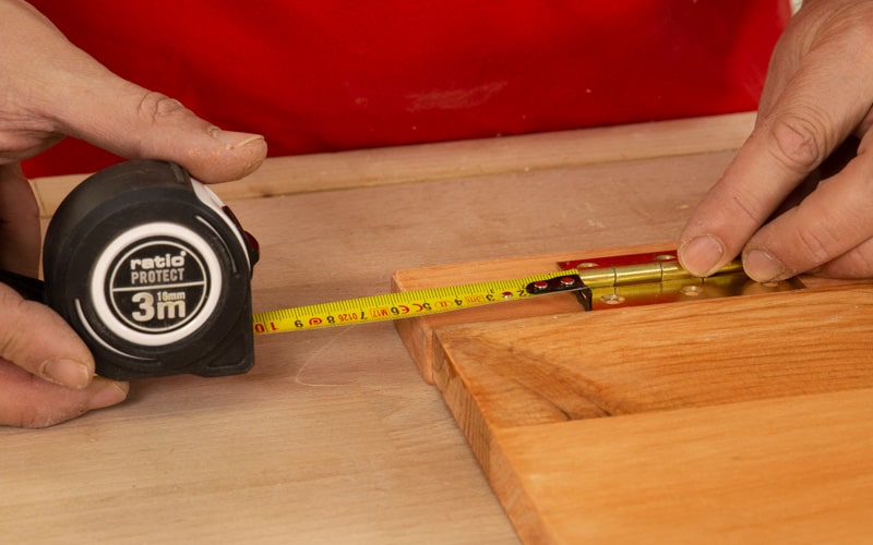 Mide donde colocarás la bisagra en la mesa de madera
